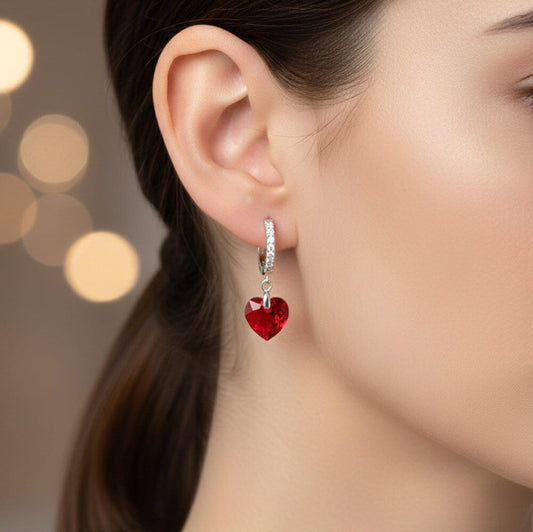 Ohrhänger am Ohr getragen, Nahaufnahme Creolen mit hängendem Herzkristall rot