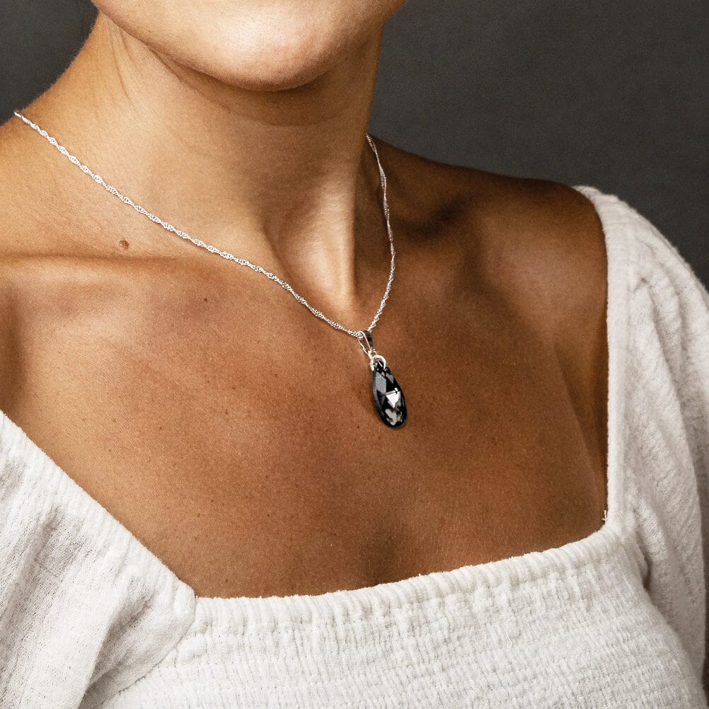 In anthrazit funkelnder Pear-shaped Tropfen Kristall mit 925 Silberkette am Hals getragen, Seitenansicht.