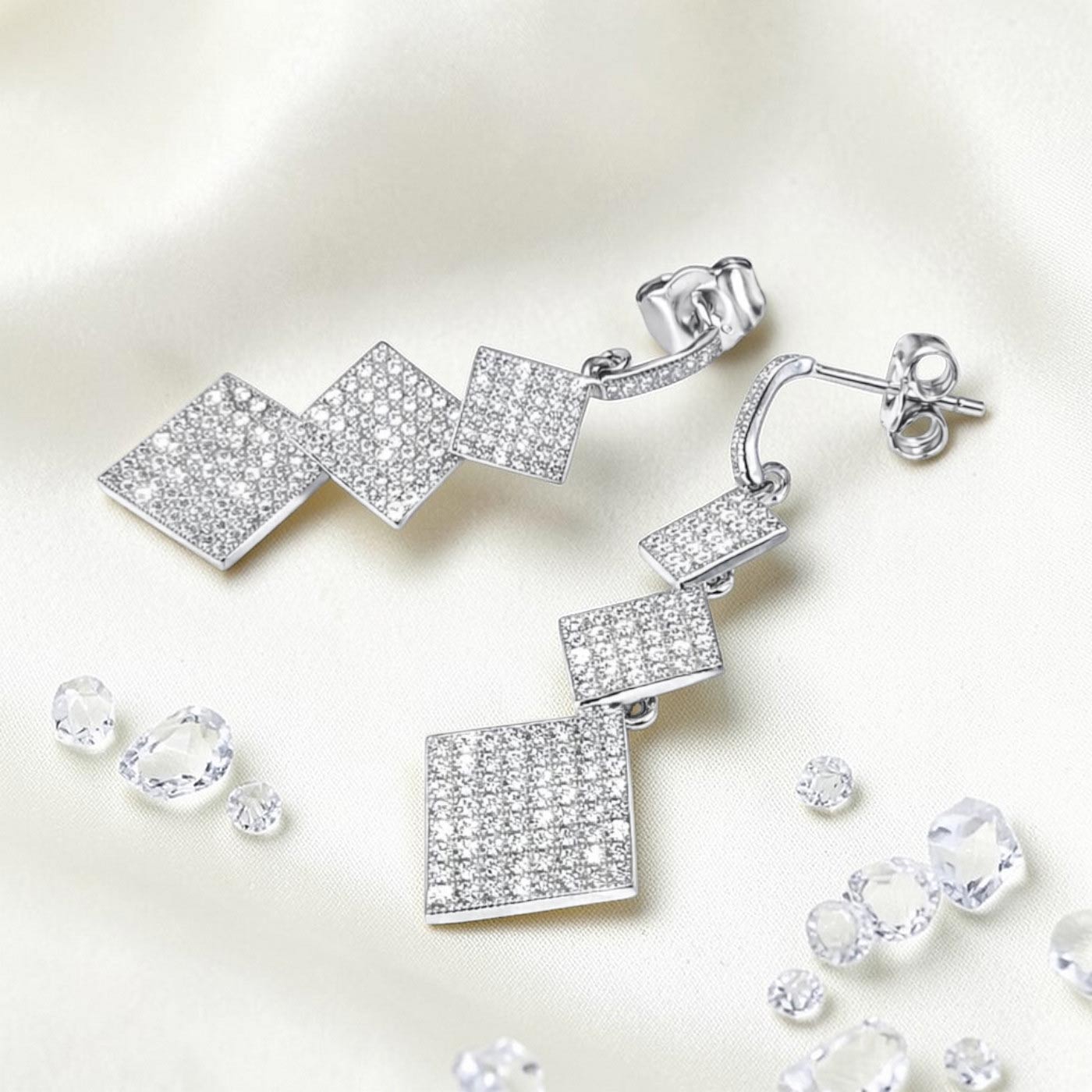 Lange Ohrringe aus 925 Silber mit 3 Pavé-Zirkonia-Quadraten Ansicht liegend