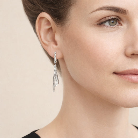 Elegante Twisted Ribbon Ohrringe aus Silber mit Zirkonia Pavé hängend am Ohr