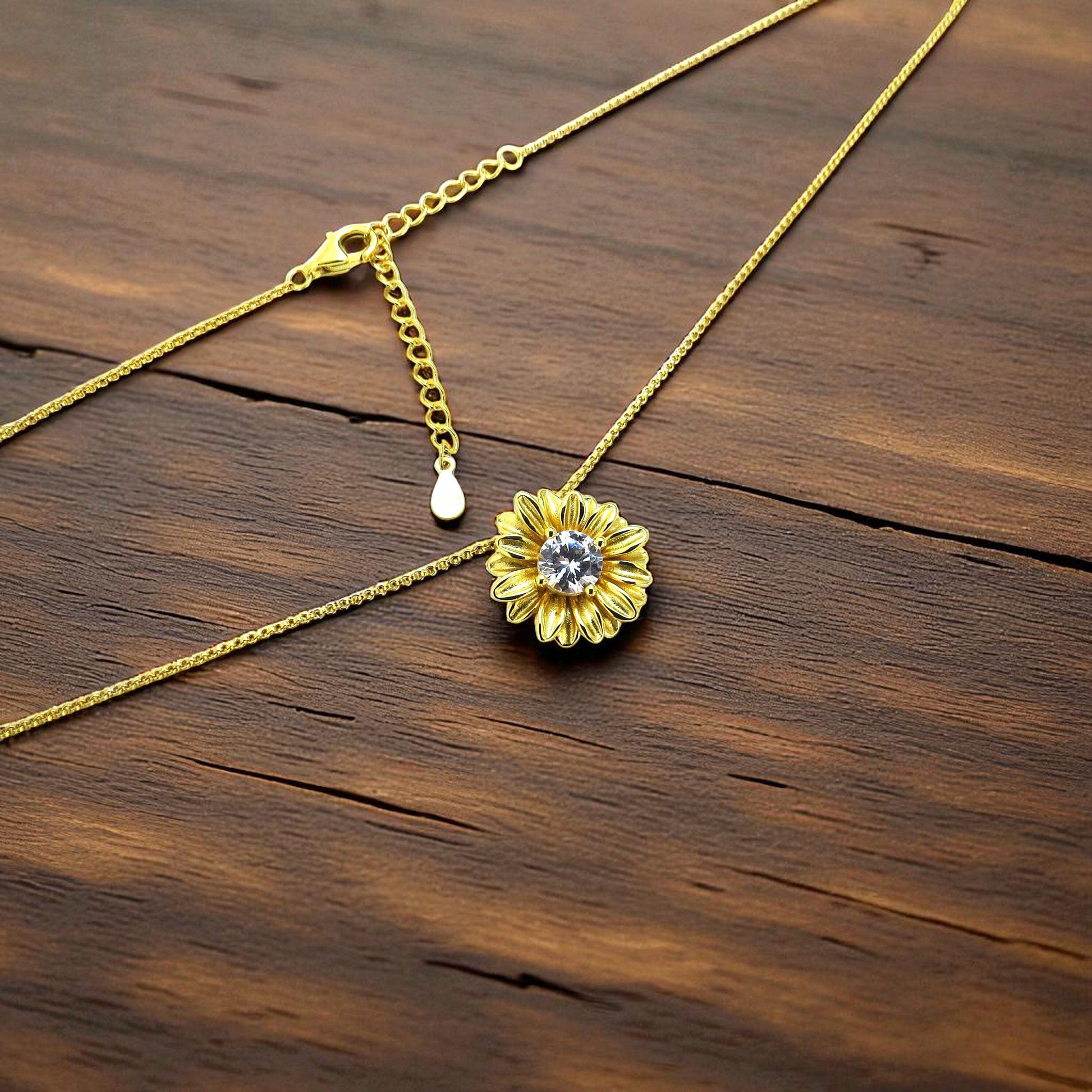 Schöner-SD liegende Ansicht der Blüten-Kette mit zentralem Zirkonia mit verstellbarer Erbskette mit Karabiner-Verschluss in Silber vergoldet.